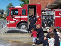 Kid spraying water hose